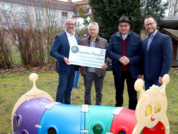 Gruppenbild auf einem Spielplatz bei der symbolischen Scheckübergabe